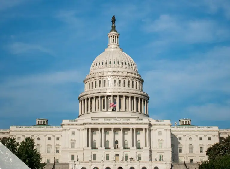 The United States Capitol building with its white dome and American flag, set against a clear blue sky, stands as an enduring symbol of the public sector pivoting to address the nation’s evolving challenges.